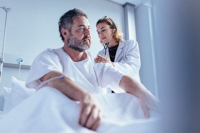 Doctor assessing male surgical patient preoperatively—highlighting the importance of nutrition screening to reduce complication and revision risks after TSA.