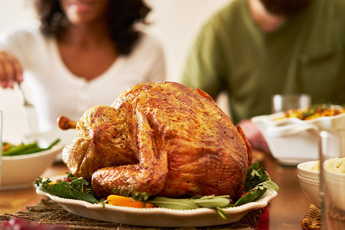 A golden roasted turkey surrounded by fall dishes, symbolizing gratitude, nourishment, and mindful eating for better gut health.