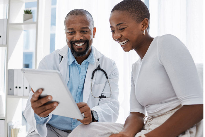 A clinician and patient reviewing health information together on a tablet, demonstrating collaborative, patient-centered decision-making that builds confidence and supports better recovery outcomes.