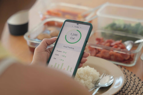 Person using a nutrition tracking app to log calories and macros, illustrating how AI can support smarter eating decisions when used thoughtfully, without over-reliance.