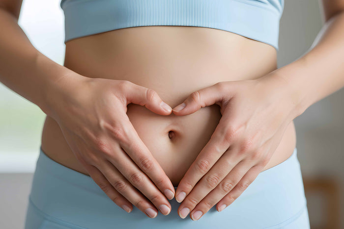 Hands forming a heart over the abdomen, symbolizing care for gut health and supporting a balanced microbiome reset.