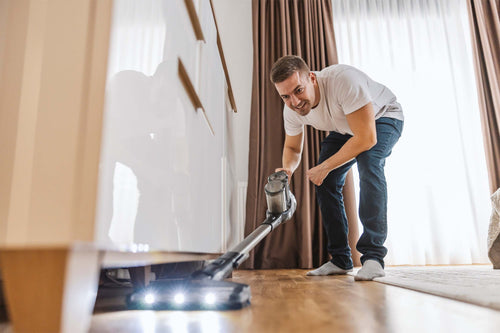 A man vacuums his home, helping reduce household dust that may contain airborne microplastic particles.