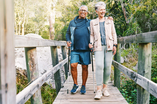 Two older adults enjoy a walk outdoors, showing how regular walking supports mobility, connection, and long-term health.